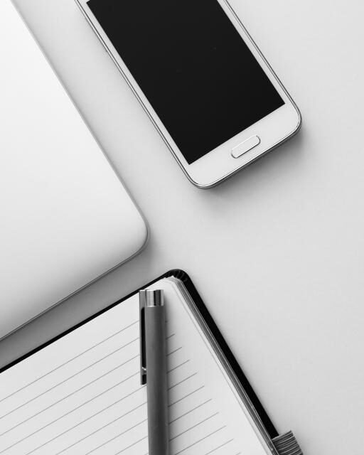 A laptop and a smartphone on a bright desk